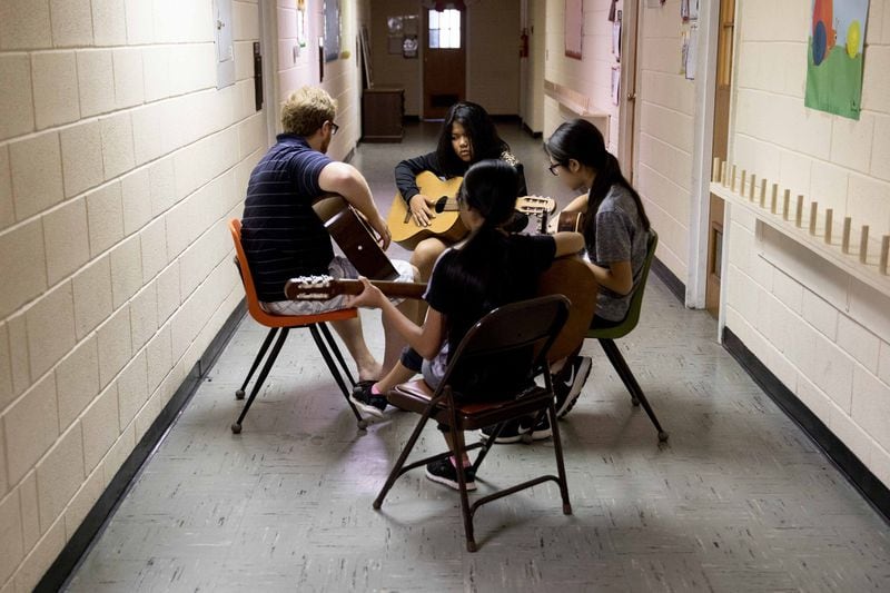 David Bentley teaches a group of girls a chord on the guitar during Free for All music lessons at Proskuneo, a music school in Clarkston that provides free lessons every Saturday morning on a variety of instruments for refugee children. Free for All lets the kids try their hand at music. BRANDEN CAMP / SPECIAL