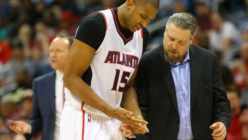 041915 ATLANTA: Trainer Wally Blase checks Hawks center Al Horford’s hand after he dislocated his pinky finger against the Nets during an NBA playoff basketball game on Sunday, April 19, 2015, in Atlanta. Curtis Compton / ccompton@ajc.com Hawks center Al Horford is tended to by trainer Wally Blase after suffering a dislocated pinky Sunday night. (Curtis Compton/ccompton@ajc.com)