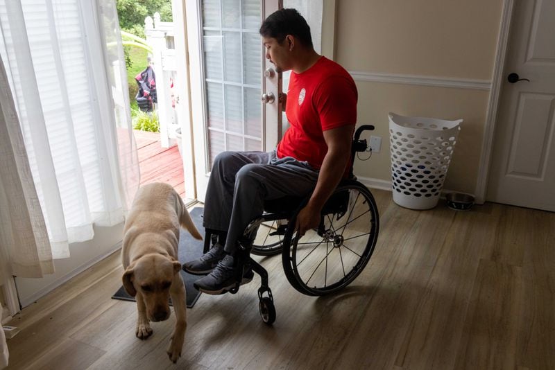 American Paralympic Medalist Justin Phongsavanh lets his dog Dixie into his McDonough home. He was paralyzed from the chest down after being shot in a parking lot in 2015. He competed for Team USA at the 2020 Tokyo Paralympics and earned the bronze in javelin & continues to train for future Paralympics. PHIL SKINNER FOR THE ATLANTA JOURNAL-CONSTITUTION