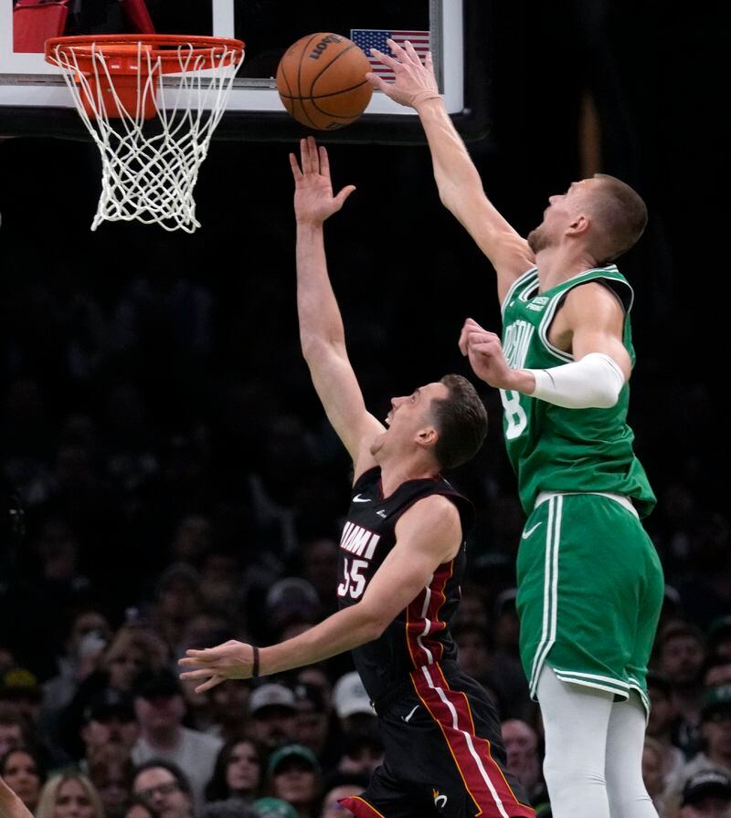 Boston Celtics center Kristaps Porzingis blocks a shot by Miami Heat forward Duncan Robinson during the first half of Game 2 of an NBA basketball first-round playoff series, Wednesday, April 24, 2024, in Boston. (AP Photo/Charles Krupa)