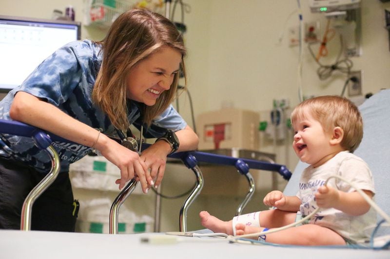 In this 2016 file photo, Amelia Ballard, a pediatric nurse at Children’s Healthcare of Atlanta’s Egleston location, treats her patient, Olen, who is 8 months old, in the emergency room. Ballard worked in the emergency department at Children's before working at the Children's Aflac Cancer and Blood Disorders Center (Emily Jenkins / AJC file photo)