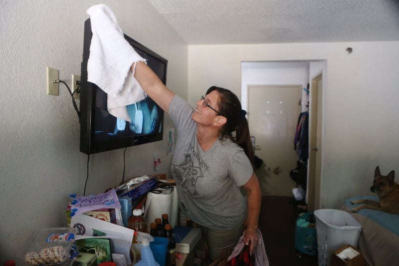 Rimbey Schroeder, 44, cleans her family’s room at the Motel 6 in Norcross that has been their home. CHRISTINA MATACOTTA / CHRISTINA.MATACOTTA@AJC.COM