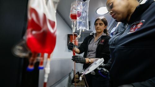 Paramedics at Grady Nicole Wilkerson (right) and Ned Vidal work through a training session on implementing a blood transfusion inside of a Quick Response Vehicle at the Grady EMS Headquarters in Atlanta. (Miguel Martinez /miguel.martinezjimenez@ajc.com)