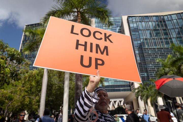 A demonstrator against former President Donald Trump holds a “lock him up” sign outside the Wilkie D. Ferguson Jr. U.S. Courthouse in Miami on Tuesday morning, June 13, 2023. (Christian Monterrosa/The New York Times)