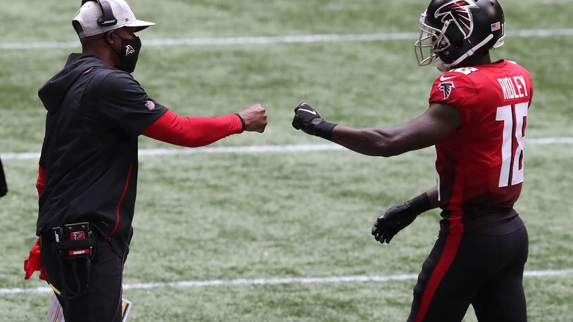 Falcons interim head coach Raheem Morris (left) greets wide receiver Calvin Ridley with a fist-bump on the sidelines after Ridley's second-quarter touchdown catch against the Detroit Lions Sunday, Oct. 25, 2020, at Mercedes-Benz Stadium in Atlanta. (Curtis Compton / Curtis.Compton@ajc.com)