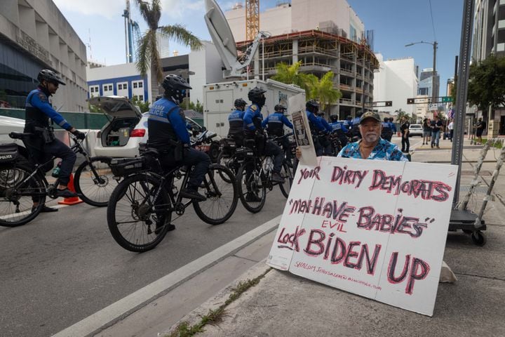 Miami Police on bicycles pass a demonstrator near the Wilkie D. Ferguson Jr. U.S. Courthouse in Miami on Tuesday morning, June 13, 2023.. (Christian Monterrosa/The New York Times)