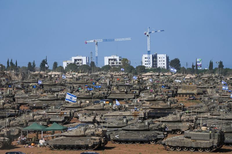 Israeli soldiers work on armored military vehicles at a staging ground near the Israeli-Gaza border, in southern Israel, Wednesday, May 8, 2024. (AP Photo/Tsafrir Abayov)