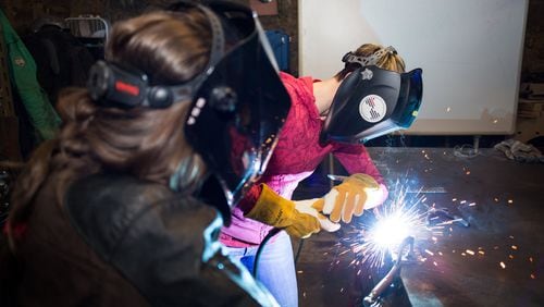Bria Sativa Aguayo, left, founder of the Atlanta-based nonprofit Becoming a Welder Inc., teaches a student during a recent welding workshop. She is trying to make women aware of the opportunities in the industry.