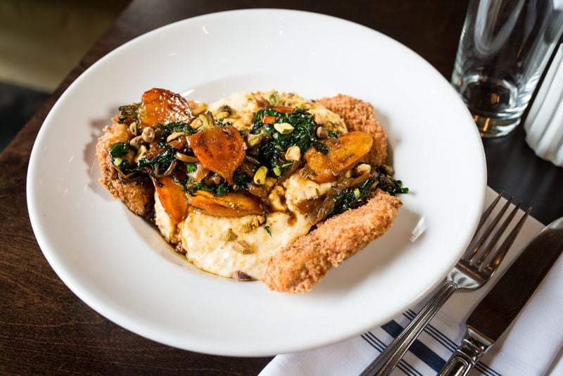 The pork schnitzel, with Gouda grits, smoked carrots, Lacinato kale, caramelized onions and pistachios, stays interesting bite after bite. CONTRIBUTED BY MIA YAKEL