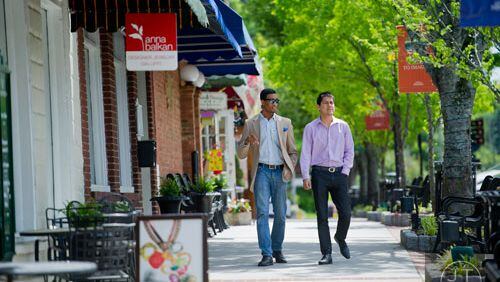 The Norcross City Council will hold a ‘Walk with Council’ 6:30 to 7:30 p.m. Aug. 2. Here: Derrick Jones (left) talks with Steven Rodriguez as they walk through downtown Norcross May 1, 2014. Courtesy File Photo by Jonathan Phillips