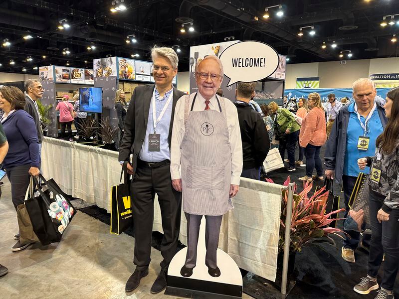 Berkshire Hathaway shareholders pose with a cutout poster of CEO Warren Buffett Friday, May 3, 2024, in Omaha, Neb., inside the exhibit hall in Omaha where Berkshire companies sell their products. Buffett will spend hours answering questions at the meeting Saturday. (AP Photo/Josh Funk)