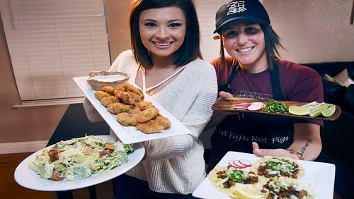 Ashley Hankins-Marchetti, left, and Ashlee Marchetti, right, create plant-based food for their blog titled Eat Figs Not Pigs. Shown left to right is Caesar salad with cashew-based dressing, pano battered fried artichokes, and street-style tacos with textured soy proten for filling. (Eric Paul Zamora/Fresno Bee/TNS)