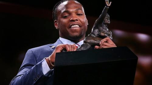 Alabama's Derrick Henry lifts up the Heisman Trophy after being announced as the winner, Saturday, Dec. 12, 2015, in New York. (AP Photo/Kelly Kline, Pool)