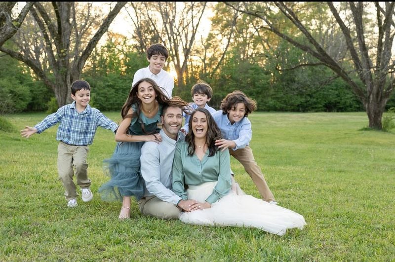Kim Airhart, pictured with her husband Chris and their five kids, helps women fight ovarian cancer as she battles her own recurrence.
Courtesy of Chey Photography