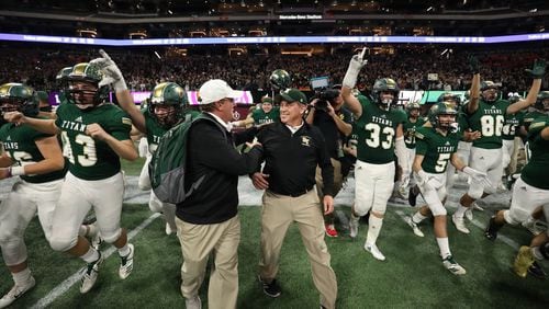 Blessed Trinity coach Tim McFarlin (center) celebrates with staff and players after their 23-9 win against Cartersville in the Class AAAA State Championship at Mercedes-Benz Stadium Wednesday, December 12, 2018, in Atlanta. (JASON GETZ/SPECIAL TO THE AJC)
