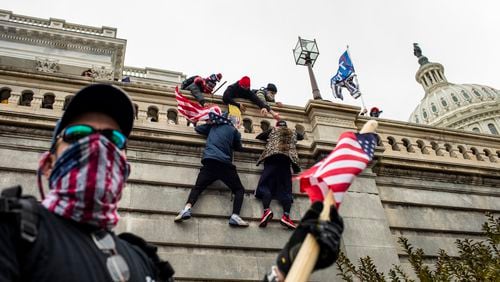 Supporters of President Donald Trump scale a wall on the Senate side of the Capitol Building in an attempt to disrupt the certification of the Electoral College results, Jan. 6, 2021. Poor planning among a constellation of government agencies and a restive crowd encouraged by President Trump set the stage for the unthinkable.(Jason Andrew/The New York Times)