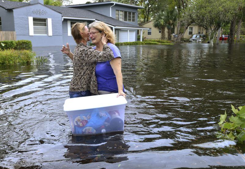Charlotte Glaze gives Donna Lamb a teary hug as she floats out some of her belongings in floodwaters from the Ortega River in Jacksonville, Fla., after Hurricane Irma passed through the area last month. DEDE SMITH / THE FLORIDA TIMES-UNION VIA AP