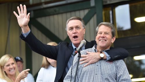 GOP gubernatorial candidate Brian Kemp (right) reacts as U.S. Senator David Perdue wishes him a happy birthday in Statesboro on Nov. 2, 2018. HYOSUB SHIN / HSHIN@AJC.COM