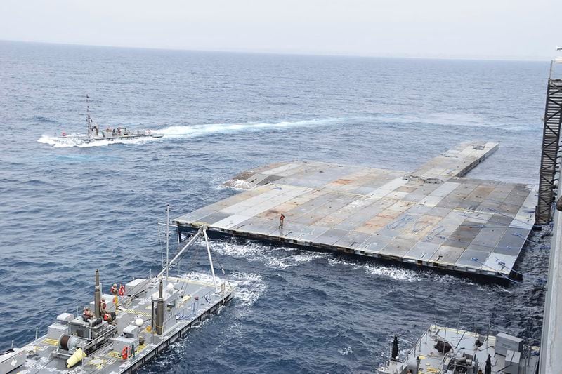 This undated photo released early Tuesday, April 30, 2024, by the U.S. military's Central Command shows construction off a floating pier in the Mediterranean Sea off the Gaza Strip. A U.S. Navy ship involved in the American-led effort to bring more aid into the besieged Gaza Strip is off shore from the enclave, slowly building out a floating platform for the operation, satellite photos analyzed Monday, April 29, 2024, by The Associated Press show. (U.S. military's Central Command via AP)