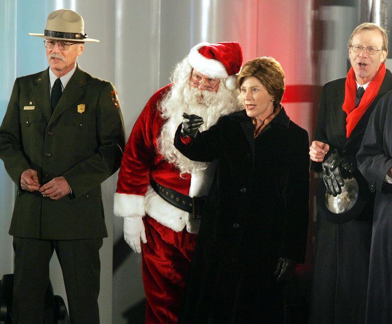 First lady Laura Bush talked to Willard Scott, dressed as Santa Claus, after the lighting of the 81st national Christmas Tree in front of the White House in 2004. An online ticket lottery for this year’s ceremony runs from Oct. 12-Oct. 16. (Photo by Joe Raedle/Getty Images)