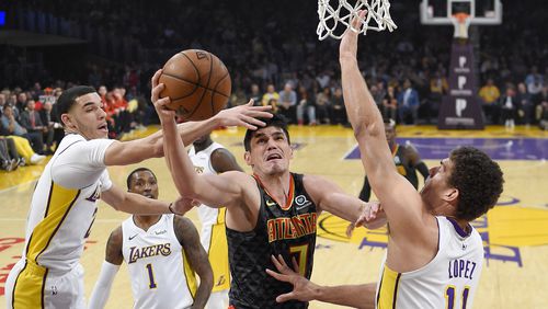 Atlanta Hawks forward Ersan Ilyasova, second from right, shoots as Los Angeles Lakers guard Lonzo Ball, left, guard Kentavious Caldwell-Pope, second from left, and center Brook Lopez defend during the first half of a basketball game, Sunday, Jan. 7, 2018, in Los Angeles. (AP Photo/Mark J. Terrill)