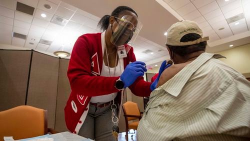 DeKalb County Board of Health medical worker Lisa Bridges administers a COVID-19 vaccination shot at the Lou Walker Senior Center in Stonecrest last week. (Alyssa Pointer / Alyssa.Pointer@ajc.com)