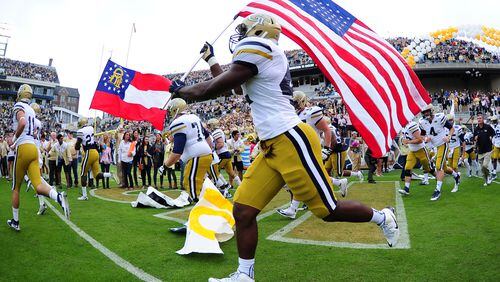 KeShun Freeman #42 of the Georgia Tech Yellow Jackets carries the American flag as he takes the field against the North Carolina Tar Heels on October 3, 2015 in Atlanta, Georgia. Photo by Scott Cunningham/Getty Images)