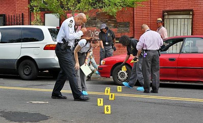 Atlanta police investigators study potential evidence at the stabbing scene from 2010. JOHN SPINK / JSPINK@AJC.COM