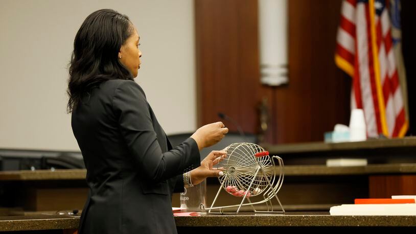 Cobb County's Chief Deputy Court Clerk Kimberly Carroll selects a numbered ball to determine which judge presides over an upcoming death penalty case.  Judge Robert E. Flournoy III was selected from eight possible judges. Bryan Anthony Rhoden is charged with murder in the shootings of three people last year at the Pinetree Country Club.
Miguel Martinez / miguel.martinezjimenez@ajc.com