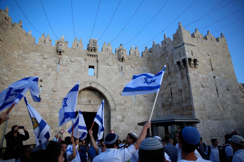Israelis wave national flags outside the Old City's Damascus Gate, in Jerusalem.