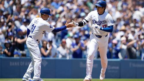 Los Angeles Dodgers designated hitter Shohei Ohtani celebrates with third base coach Dino Ebel (91) after hitting a home run during the first inning of a baseball game against the Atlanta Braves in Los Angeles, Sunday, May 5, 2024. (AP Photo/Ashley Landis)