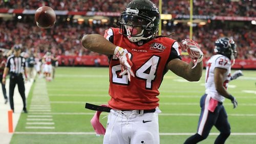 Falcons running back Devonta Freeman celebrates his first of three touchdowns on the day getting past Texans Quintin Demps for a 7-0 lead during the first quarter in a football game on Sunday, Oct. 4, 2015, in Atlanta.