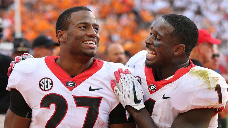 FILE - In this Sept. 30, 2017, file photo, Georgia tailbacks Nick Chubb, left, and Sony Michel celebrate on the sidelines during the fourth quarter of a 41-0 shut out over Tennessee in a NCAA college football game, in Knoxville. It's difficult to imagine Rose Bowl-bound Georgia being one of the final four teams competing for the national championship if not for the decisions by tailbacks Nick Chubb and Sony Michel to return for their senior seasons. The SEC championship and spot in the College Football Playoff is exactly what they hoped to accomplish. B (Curtis Compton/Atlanta Journal-Constitution via AP, File)