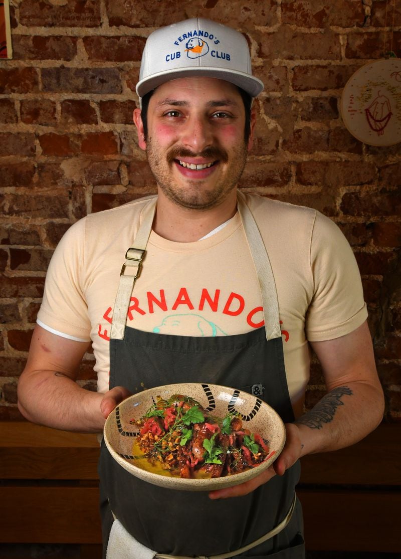 Jarrett Stieber, chef and owner of Little Bear on Georgia Avenue in Atlanta, holds Sausage over Hazelnut Quinoa with Roasted Carrots and Coffee Vinaigrette, a dish he developed. (Styling by Jarrett Stieber / Chris Hunt for the AJC)