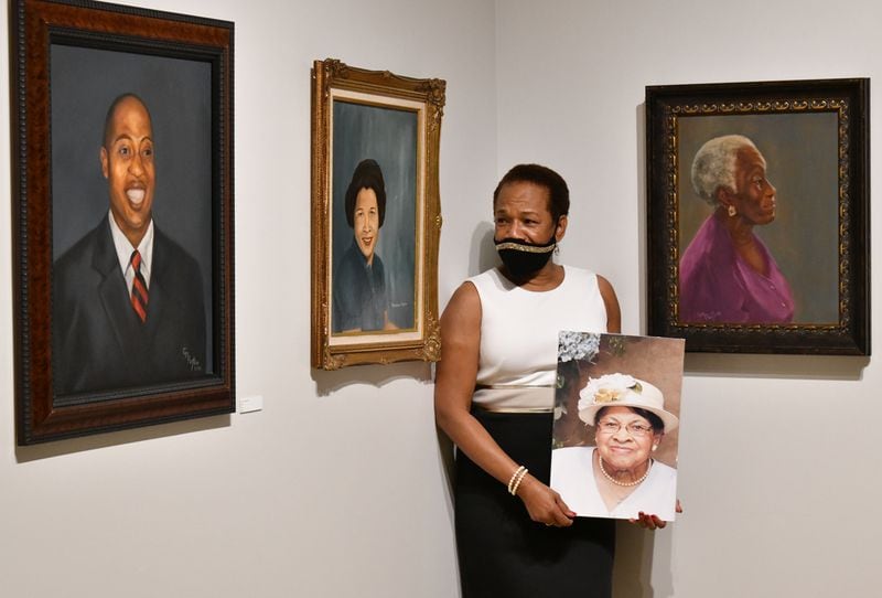 Gwendolyn Payton gets emotional as she holds a photograph of her late mother, Johnnie Mae Middleton, in front of her mother's portrait she painted at her new gallery exhibition at Plunkett Gallery in the Hardman Hall Fine Arts Building at Mercer University in Macon on Friday, Sept. 25, 2020. Gwendolyn Payton, after nearly 50 years, is getting her senior art show, denied to her by the head of the Mercer art department back then. Hyosub Shin / Hyosub.Shin@ajc.com