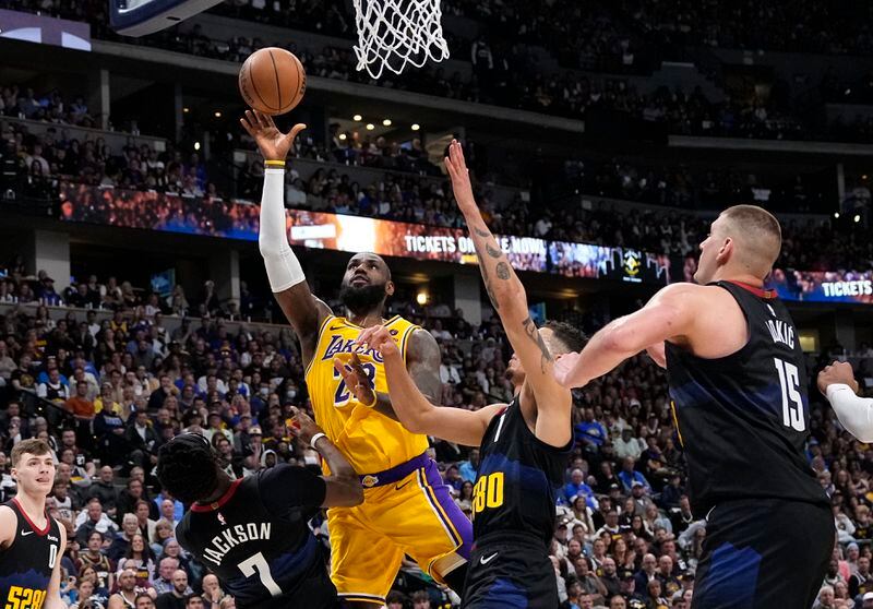 Los Angeles Lakers forward LeBron James (23) goes up for a shot against Denver Nuggets guard Reggie Jackson (7) and center Nikola Jokic (15) during the second half in Game 2 of an NBA basketball first-round playoff series Monday, April 22, 2024, in Denver. (AP Photo/Jack Dempsey)