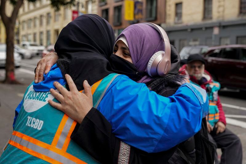 Tatiana Alabsi, left, is hugged by her sister-in-law Bushra Tanaka Alabsi while working in the Tenderloin neighborhood Wednesday, March 27, 2024, in San Francisco. (AP Photo/Godofredo A. Vásquez)