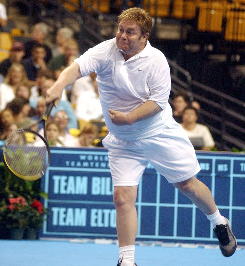 BOSTON - SEPTEMBER 25:  Elton John lunges for the ball during "The Battle of the Sexes Celebrity Doubles" tennis match on September 25, 2003 at the Fleet Center in Boston, MA.   Elton John and Andre Agassi played doubles against Anna Kournikova and Andre Agassi for the ADT World Team Tennis (WTT) Smash Hits charity event held in Boston to raise money for Elton John's AIDS Foundation. (Photo by Jessica Rinaldi/Getty Images)