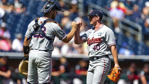 Auburn pitcher Blake Burkhalter (40) and catcher Nate LaRue (28) fist bump after the seventh inning against Stanford in an NCAA College World Series baseball game Monday, June 20, 2022, in Omaha, Neb. (AP Photo/John Peterson)