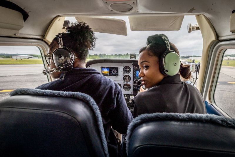 Aviation Career Enrichment Academy flight instructor Ashley Moss (right) looks for traffic in the school's Cessna 175 with student pilot Kelsey Griffin, 15, before their flight at Brown Field In Atlanta on Saturday, April 20, 2024.  (Steve Schaefer / AJC)