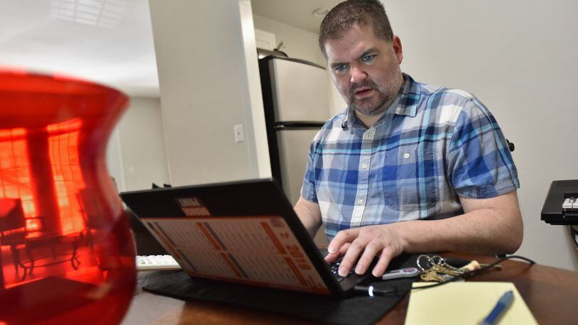 Patrick Hill works on his laptop at his apartment home in Sandy Springs. The CPA is now a full-time employee at Home Depot, but he worked contract jobs for a decade. HYOSUB SHIN / HSHIN@AJC.COM