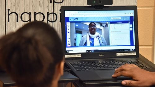 Telemedicine is taking initial steps in Georgia. At Fickett Elementary School in Atlanta, students can obtain medical advice from doctors and nurses virtually. In this photo, fourth-grader Sonja Leonard listens as pediatric nurse practitioner Martha Cargill speaks on a computer from her clinic. (PHOTO by HYOSUB SHIN / HSHIN@AJC.COM)