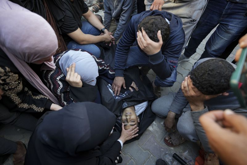 Palestinians mourn over a killed family member in the Al Aqsa hospital in Deir al Balah following an Israeli bombardment in the Maghazi refugee camp, central Gaza Strip, Tuesday, April 16, 2024. Several killed in a strike in Maghazi camp in Central Gaza on Tuesday. (AP Photo/Abdel Kareem Hana)
