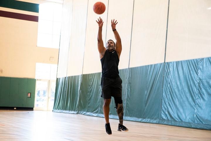 Tiran Jackson shoots a basketball on the courts at Life Time Woodstock on Wednesday, July 6, 2022, in Woodstock, Georgia. Jackson said fitness is important to him to ensure he can continue to walk and maintain his balance with his leg and prosthetic. (Chris Day/Christopher.Day@ajc.com)