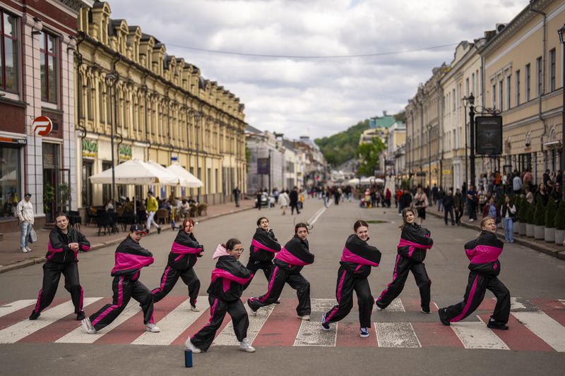 Young girls perform a choreographed group dance at Kontraktova square in Kyiv, Ukraine, Saturday, April 20, 2024. (AP Photo/Francisco Seco)