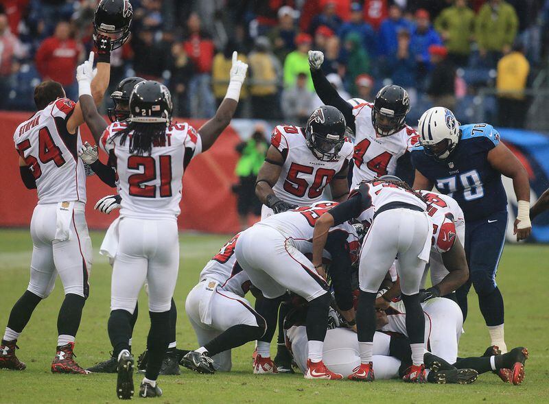 102515 NASHVILLE: -- Falcons begin to celebrate and dig safety Robenson Therezie out of the pile after he intercepted Titans quarterback Zach Mettenberger in the final minutes of the game to hold on to a 10-7 victory in a football game on Sunday, Oct. 25, 2015, in Nashville. Curtis Compton / ccompton@ajc.com