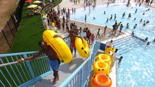 Kendric Taylor (front) makes his way up the stairs of one of the water slides at the Browns Mill Aquatic Center. Renee’ Hannans Henry/AJC.