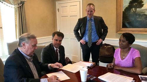 Powder Springs Development Authority Chair Murray Homan (far left) and Treasurer Krystal Wattley (right) sign the bond purchase resolution with Searles bond counsel David Williams and DAPS bond attorney Thomas Lauth (standing L-R). Courtesy of Powder Springs