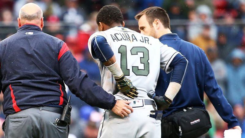 Braves outfielder Ronald Acuna is helped off the field after an injury at first base in the seventh inning of a game May 27, 2018 , against the Boston Red Sox at Fenway Park in Boston. (Adam Glanzman/Getty Images)