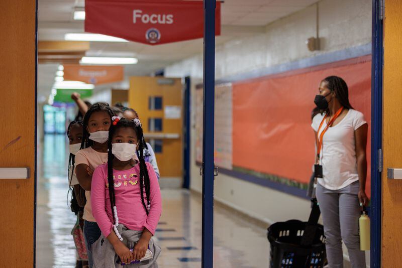 Students line up in the hallway at T.H. Slater Elementary School. The school’s enrollment grew from a projected 460-490 students to over 560 as Forest Cove children showed up. (Arvin Temkar / arvin.temkar@ajc.com)